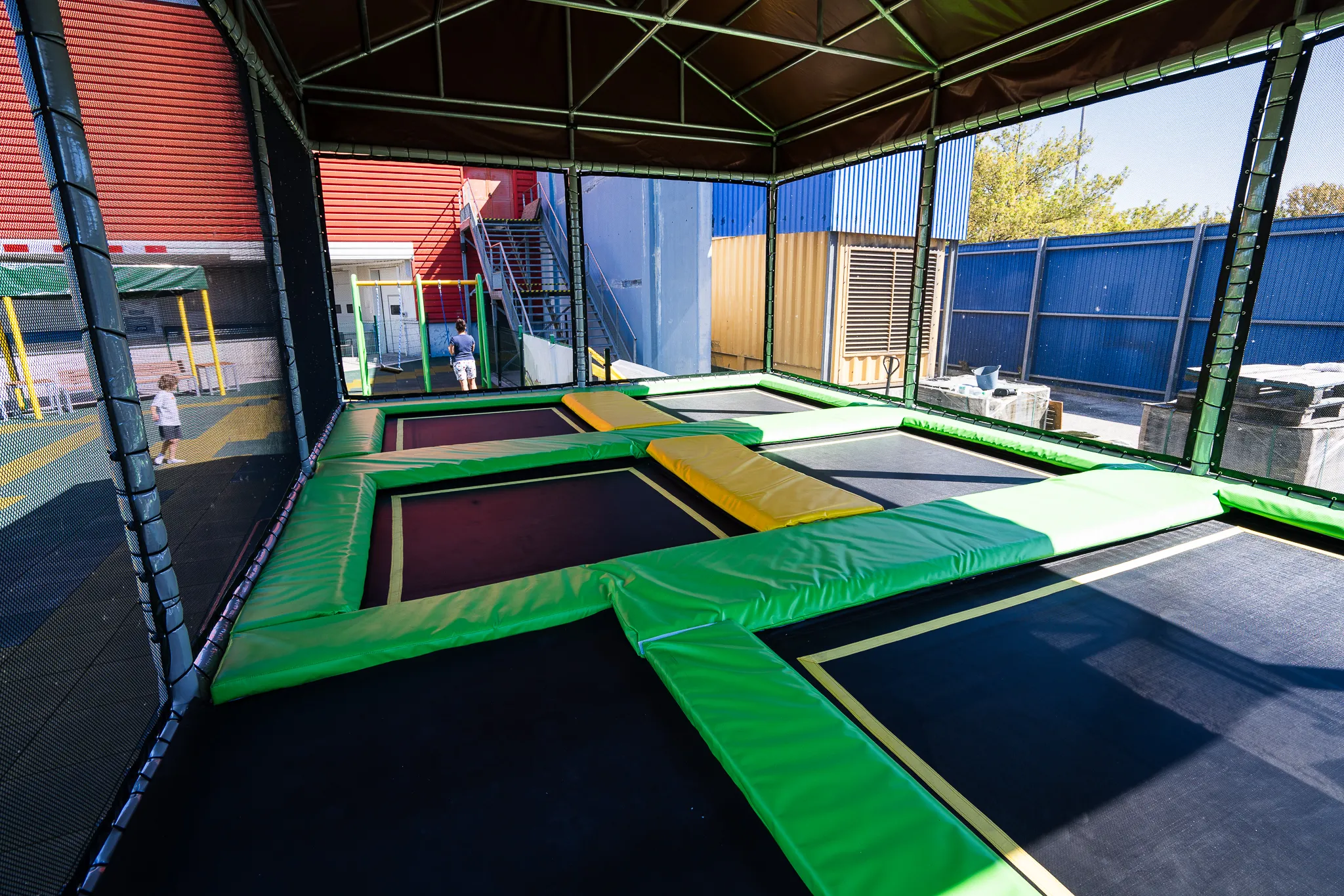 Zastrešená trampolínová zóna s ochrannou sieťou na detskom ihrisku Legia Fitness.